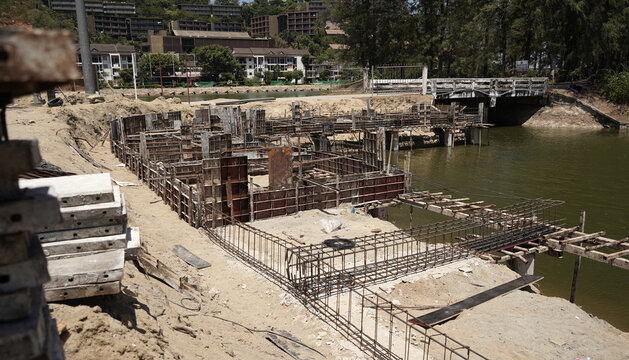 Building process city levee. Exposed foundation rebar grid at site, standing formwork and concrete footings