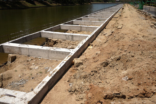Building process city levee. Exposed foundation rebar grid at site, standing formwork and concrete footings