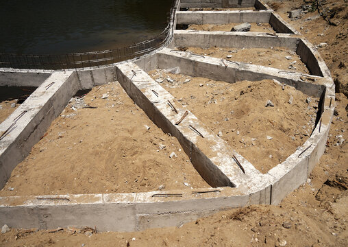 Building process city levee. Exposed foundation rebar grid at site, standing formwork and concrete footings