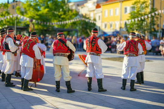 Group of musicians wearing authentic Croatian folk costumes performing traditional music during Ethno Festival in Selce, Croatia. 