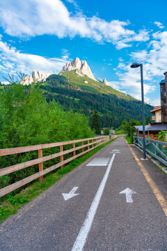 Paved cycling and walking path leading toward the dramatic Sassolungo mountain massif in the Dolomites, South Tyrol, Italy