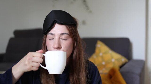 Young woman slowly sips her morning coffee letting the familiar taste wake her up as the comforting ritual becomes the favorite way to begin a peaceful new day