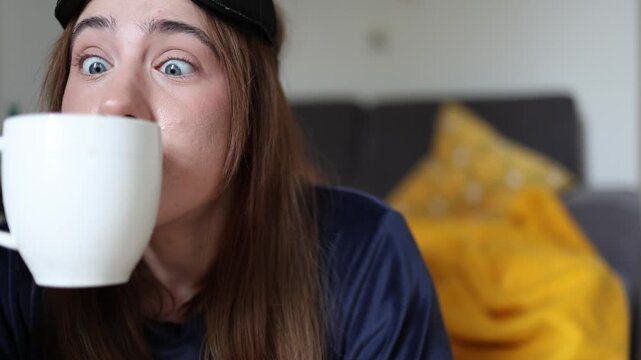 Coffee aroma becomes the only reason to smile each morning as a sleepy young woman finds comfort and energy in the first sip that finally lifts her mood today