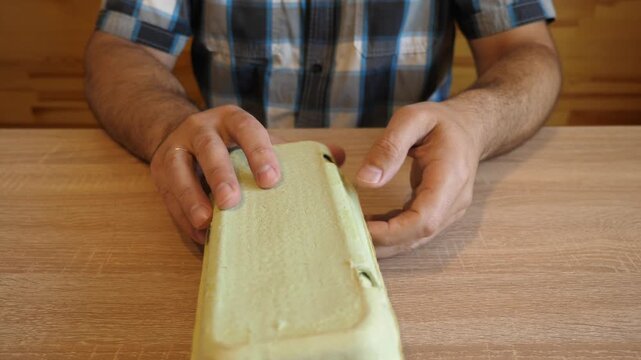 Person opens and closes a cardboard egg carton. The original audio captures the distinctive sound of folding cardboard and the lid closing.