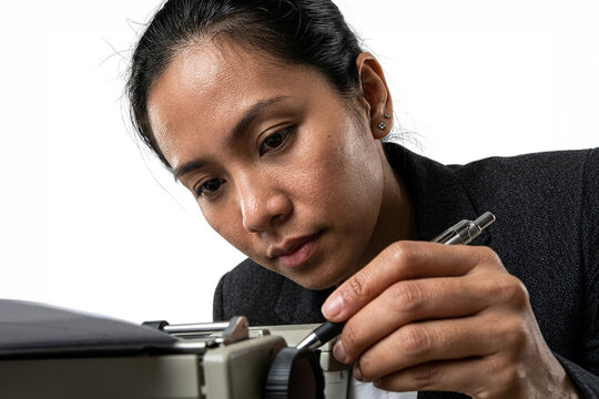 Woman using a magnifying glass to inspect a vintage typewriter