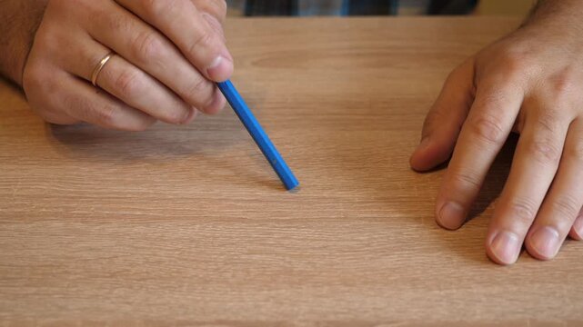 Person repeatedly taps a wooden pencil on a wooden tabletop. The original audio captures the distinctive sound of the pencil striking the surface.