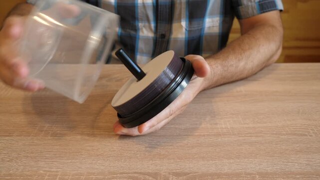 Person unscrews the lid of a plastic DVD disc spindle case. The original audio captures the distinctive sound of the threaded lid unscrewing.