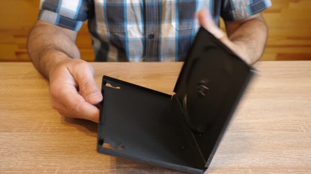 Person opens an empty plastic DVD case. The original audio captures the distinctive sound of the plastic case opening.