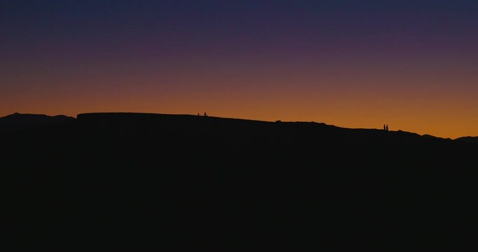 Silhouetted People Walking Along Ridge at Zabriskie Point Sunset, Death Valley
