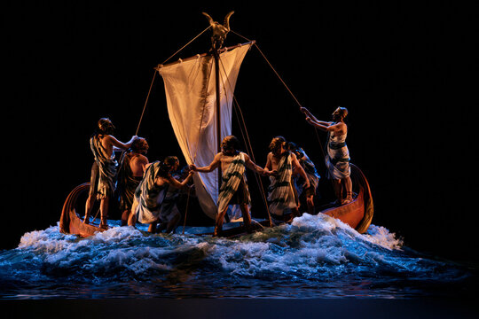A captivating theatrical portrayal of Odysseus and his valiant crew navigating a turbulent sea aboard their ancient sailing vessel, vividly depicting the legendary Greek odyssey's perilous