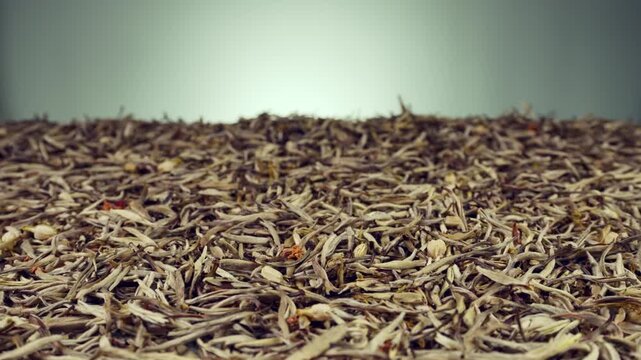 Macro video of traditional jasmine tea scenting process with fresh white jasmine buds and dried tea leaves, organic herbal beverage craft, luxury tea culture background for commercial use