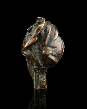 Abstract bronze sculpture inspired by a bird form, created by sculptor Lukas Teguara, photographed on black background.