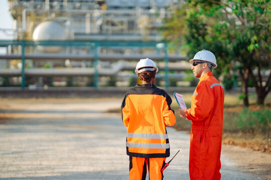 Engineering professionals inspecting industrial processing facility while discussing maintenance strategy. Plant inspection, technical collaboration, asset management and industrial safety.