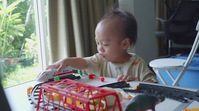 A young child enjoys playtime with colorful toy trains and dinosaurs, surrounded by a vibrant environment. The playful scene captures the essence of childhood imagination and creativity.