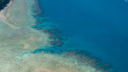 Aerial view of coral reef patterns in turquoise water © The Long Horizon