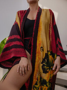 Close up of woman wearing luxury kimono robe over  swimsuit