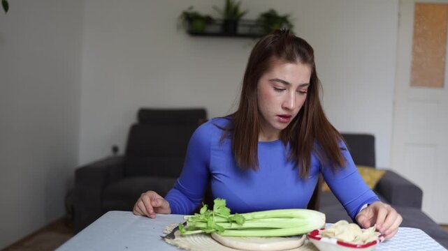 Healthy eating tests willpower as young woman checks the time before deciding between celery and potato chips revealing calorie obsession and daily food anxiety