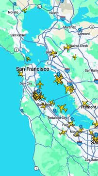 Air traffic over San Francisco Bay Area with multiple aircraft icons, Aviation overview showing commercial flights across coastal California urban region, vertical footage