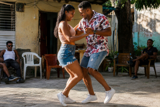 Couple dancing together in a sunlit outdoor courtyard