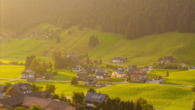 Alpine green fields and traditional wooden houses view of the Gosau village at summer sunny morning.