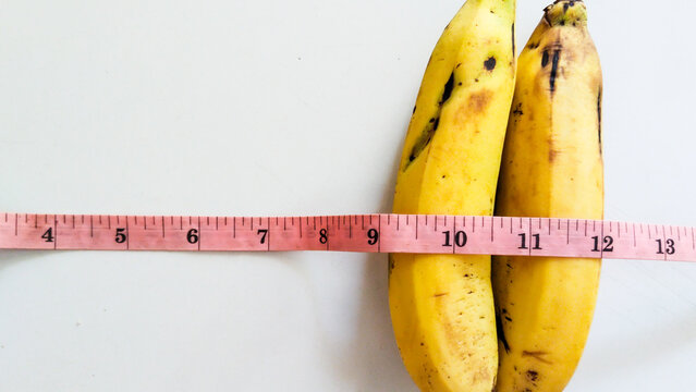 measuring tape with two yellow banana isolated on white