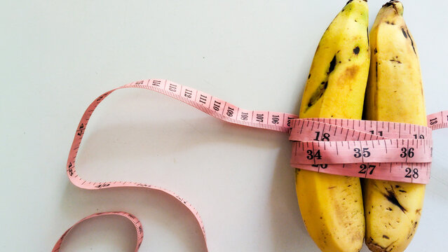 measuring tape with two yellow banana isolated on white