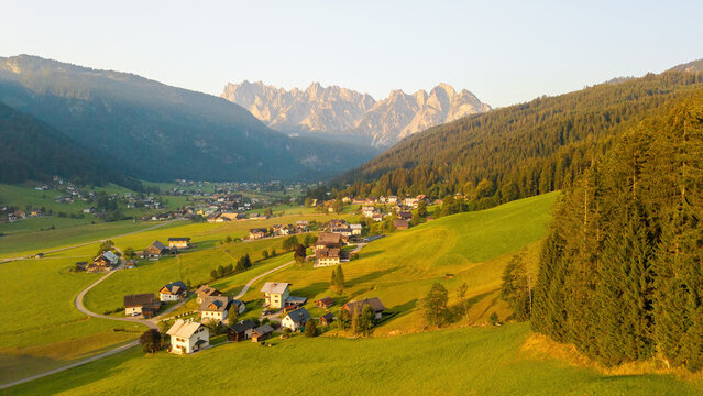 Alpine green fields and traditional wooden houses view of the Gosau village at summer sunny morning.