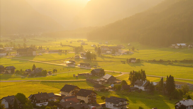 Alpine green fields and traditional wooden houses view of the Gosau village at summer sunny morning.