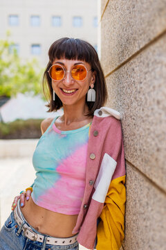 Smiles, is happy and laughs: a fashionable woman in a city style, with fashionable and simple clothes. A portrait of a woman in urban clothing.