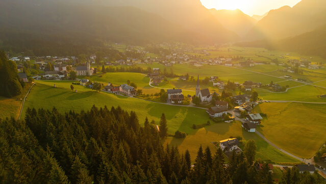 Alpine green fields and traditional wooden houses view of the Gosau village at summer sunny morning.