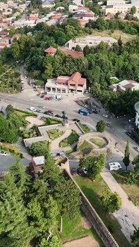 Aerial view of erekle ii square with its monument and fortress walls, showcasing the historic architecture and vibrant cityscape of telavi, georgia, surrounded by lush greenery