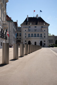 Prospettiva stradale con dissuasori stradali in metallo cilindrici che conducono all'ala presidenziale Leopoldinischertrakt del palazzo dell'Hofburg a Vienna