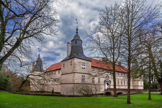Westerwinkel Castle in Germany three quarter view from park. Early baroque fortress building lawn under daytime sky
