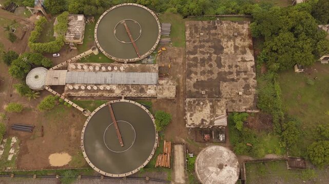 Aerial top view of wastewater treatment plant with circular clarifier tanks and industrial water processing facility in India