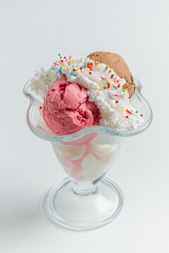 Delicious dessert featuring vibrant ice cream and fluffy whipped cream in a classic glass dish