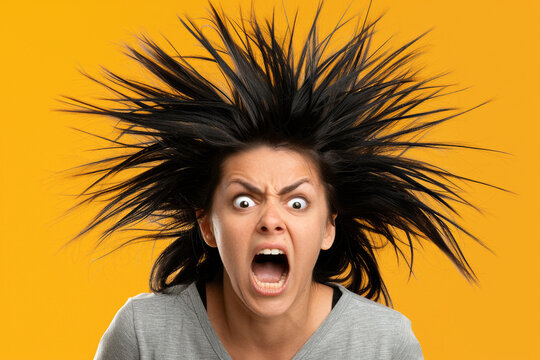 Woman with wild hair screaming on a yellow background