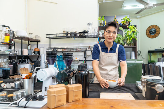 Portrait of Barista serving cafe latte to customer at cafe counter, professional beverage drink preparation specialty coffee and tea shop, small business hospitality and takeaway drink service