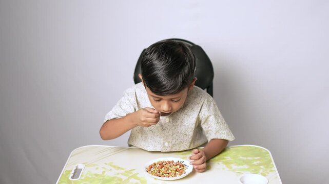 Indian boy eating healthy food. Child having a meal at home.