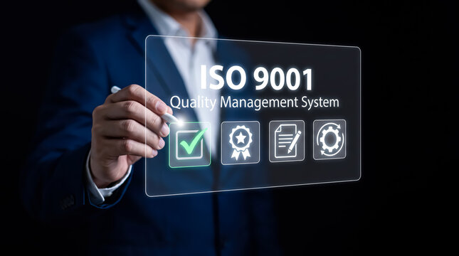 Businessman holding a digital screen with iso 9001 quality management system icon, business process improvement and standardization concept