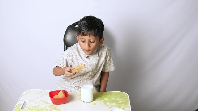 Indian boy eating bread and milk. Child having healthy breakfast at home in Delhi NCR.