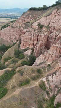 Vertical drone shot of Rapa Rosie red cliffs clay formations in Transylvania Romania