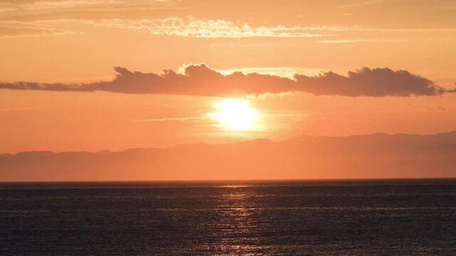Sunset Over the Ocean with Dramatic Clouds and Golden Sky at Dusk, 4K Video