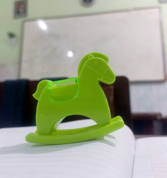 green horse toy and sharpener on a class school
