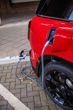 Ein E-Auto wird an einem Ladebordstein auf der K&Ouml; mit einem Kabel aufgeladen, D&uuml;sseldorf, Deutschland