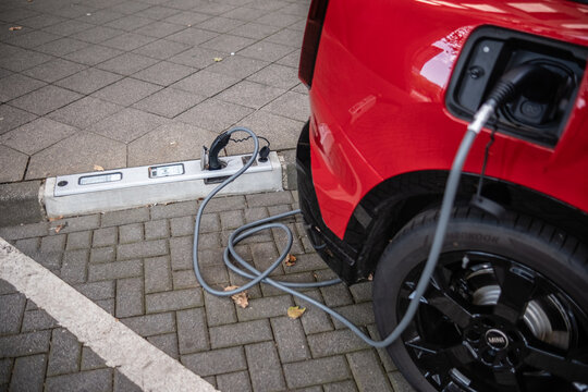 Ein E-Auto wird an einem Ladebordstein auf der K&Ouml; mit einem Kabel aufgeladen, D&uuml;sseldorf, Deutschland