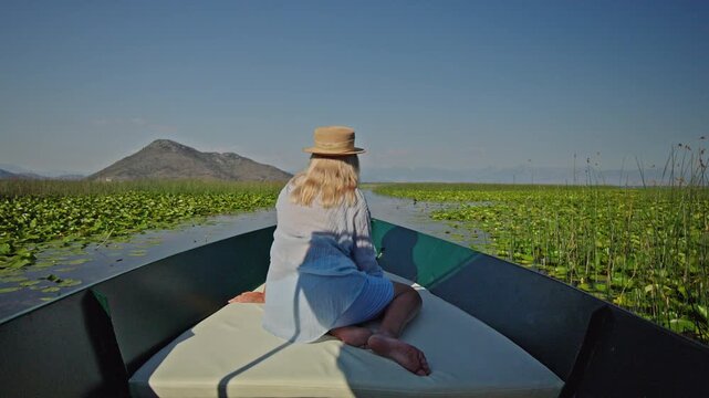 Woman relaxing during a boat trip through the waterways of Skadar Lake National Park in Montenegro.