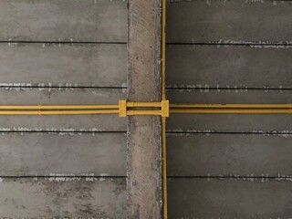 Fototapeta premium Yellow pipe pattern on concrete wall