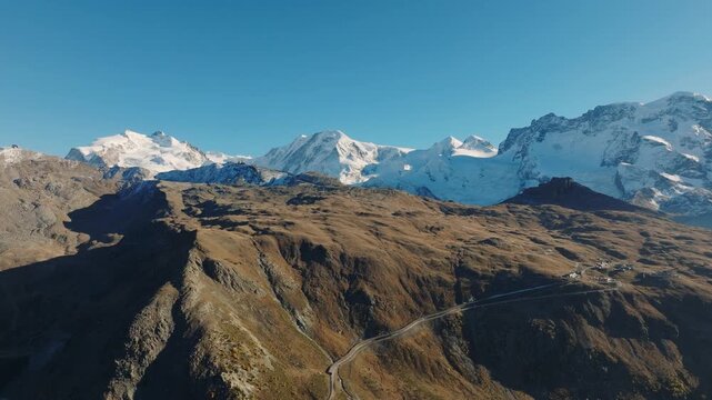 Aerial drone view of a mountain valley with dense forest surrounded by high alpine peaks. Travel and nature landscape concept.
