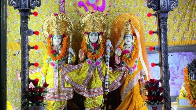 Sacred idols of Lord Rama, Goddess Sita, and Lord Lakshman adorned with colorful garments and floral decorations inside a temple, reflecting devotion, faith, and Hindu traditions.
