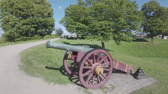 Slow motion detail of a bronze cannon barrel and carriage